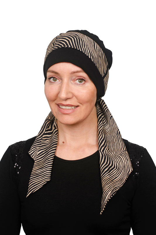 Women wearing cancer hat thats black with an animal print scarf headcovering