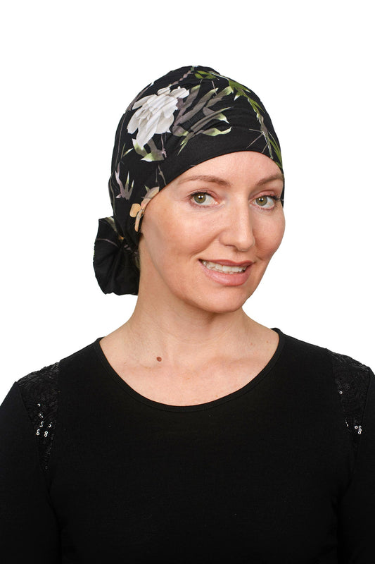 women wearing a cancer turban thats in black and floral design that is knit as a headwrap