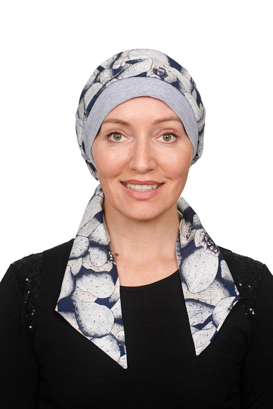 A women wearing a grey silver cancer cap with a scarf threaded through as a headwrap