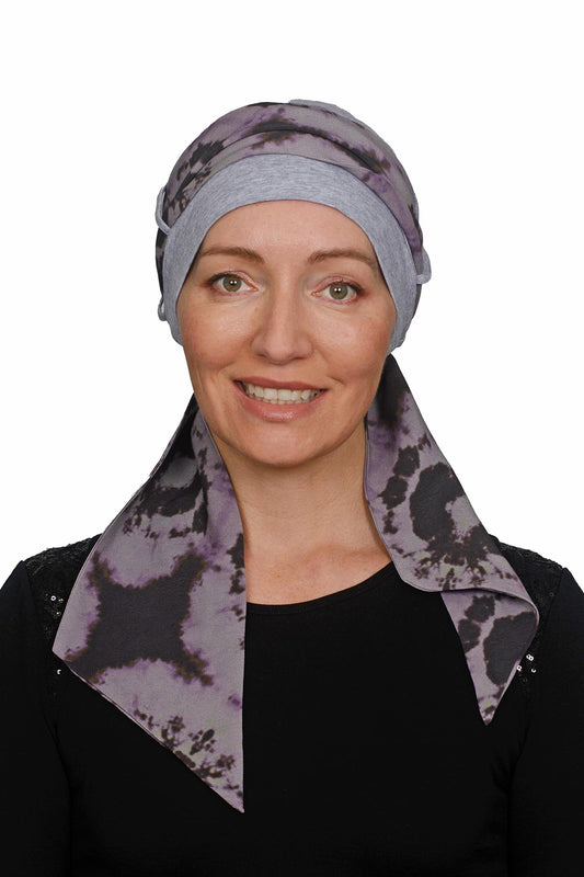 Woman wearing a purple patterned headscarf for cancer patients on a white background