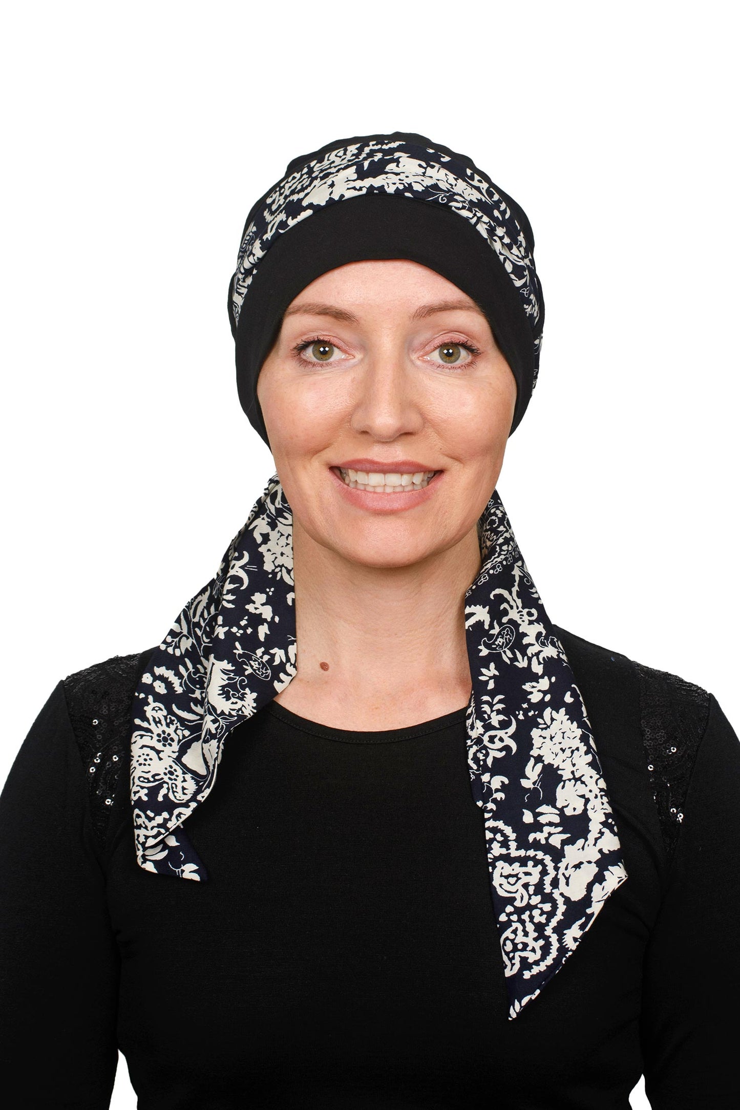 Women wearing a black cap with a black and white scarf for cancer as a headwrap