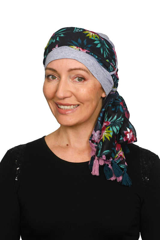 Women wearing a silver cap for cancer with a scarf that is long and colourful worn as a head wrap