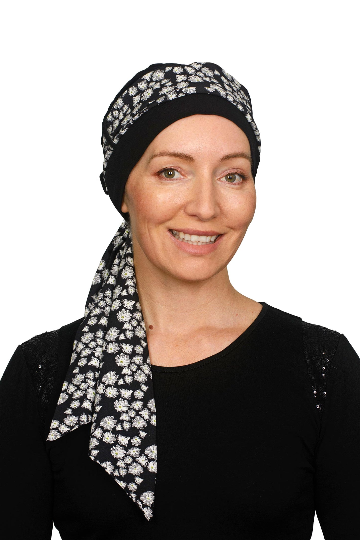 Women wearing a black cancer cap with a daisy print on it as a head covering