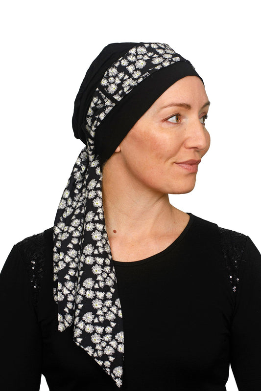Women wearing a black cancer cap with a daisy print on it as a head covering