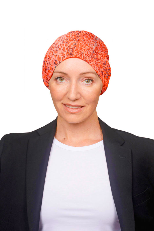Women wearing an orange cotton wrap hat as a head covering for hair loss
