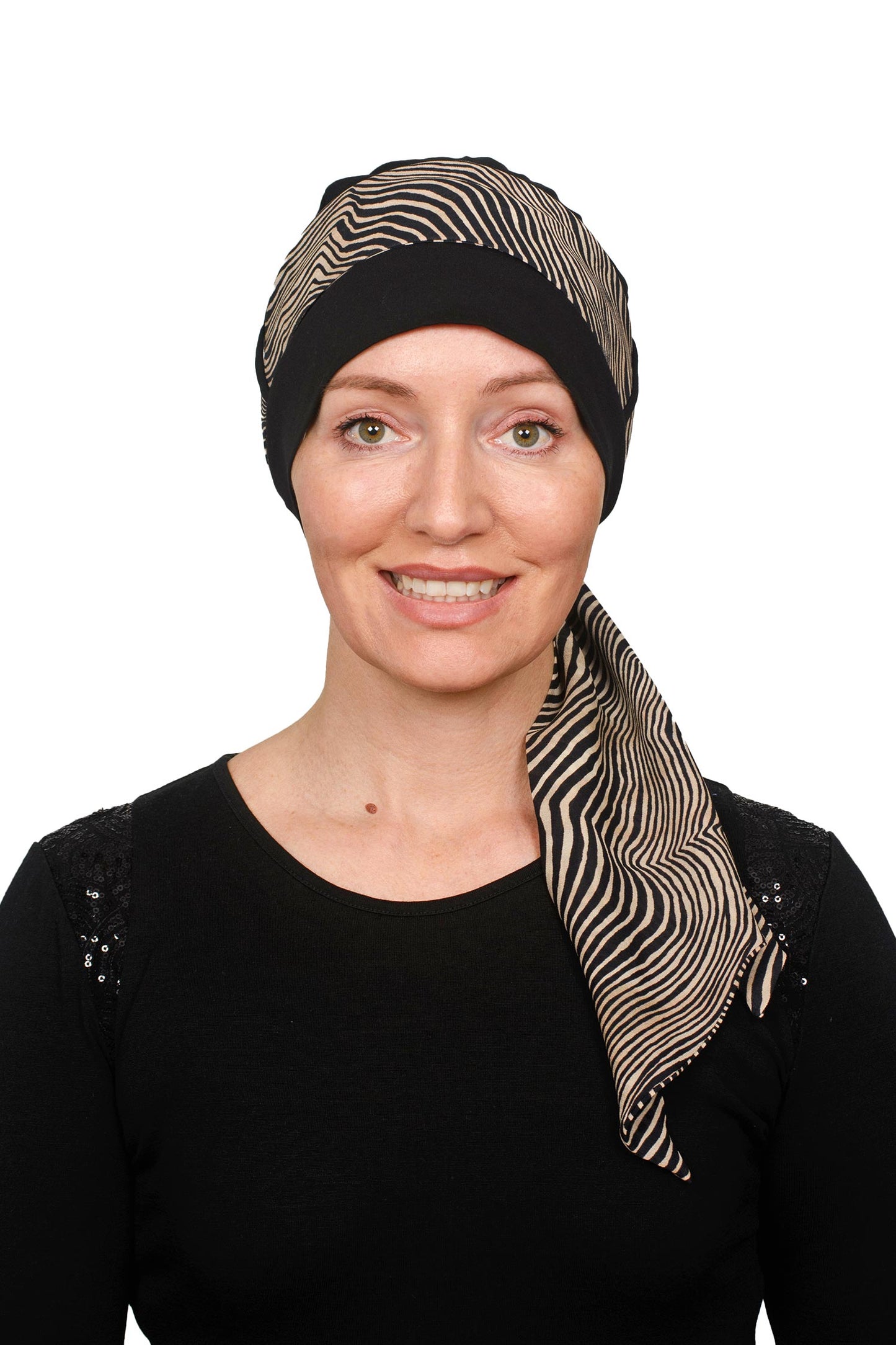 Women wearing cancer hat thats black with an animal print scarf headcovering