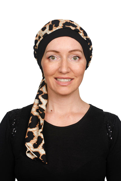 Animal Cancer Cap with a scarf threaded throgh it in black worn as a headcovering.