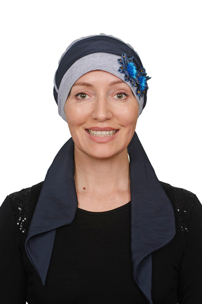 Woman wearing a cancer headscarf with a floral accessory on a white background