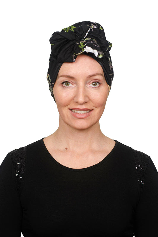 women wearing a cancer turban thats in black and floral design that is knit as a headwrap