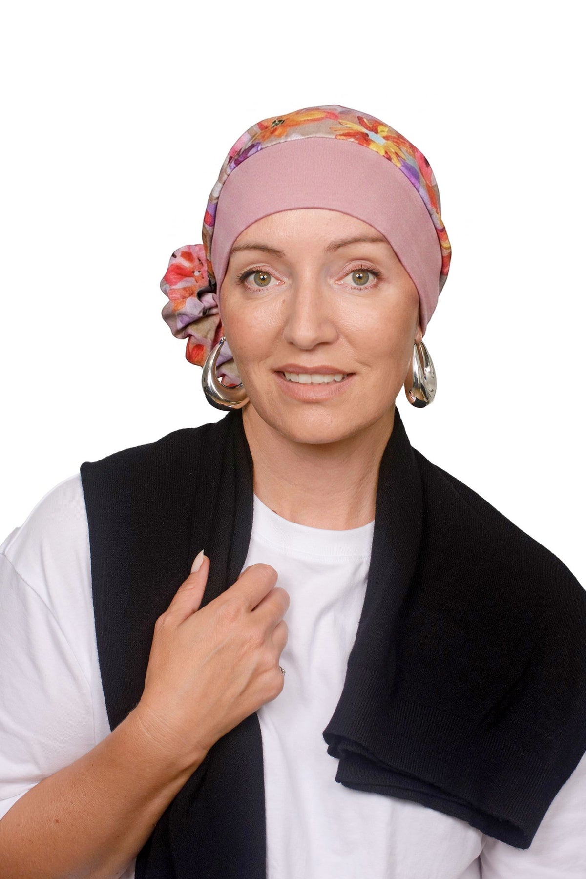 A women wearing a head scarf in pretty pink with a floral design on it as a head covering