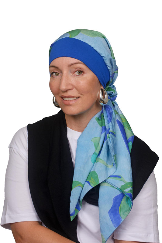 Women wearing a blue and watercolour scarf with band for cancer as a headcovering