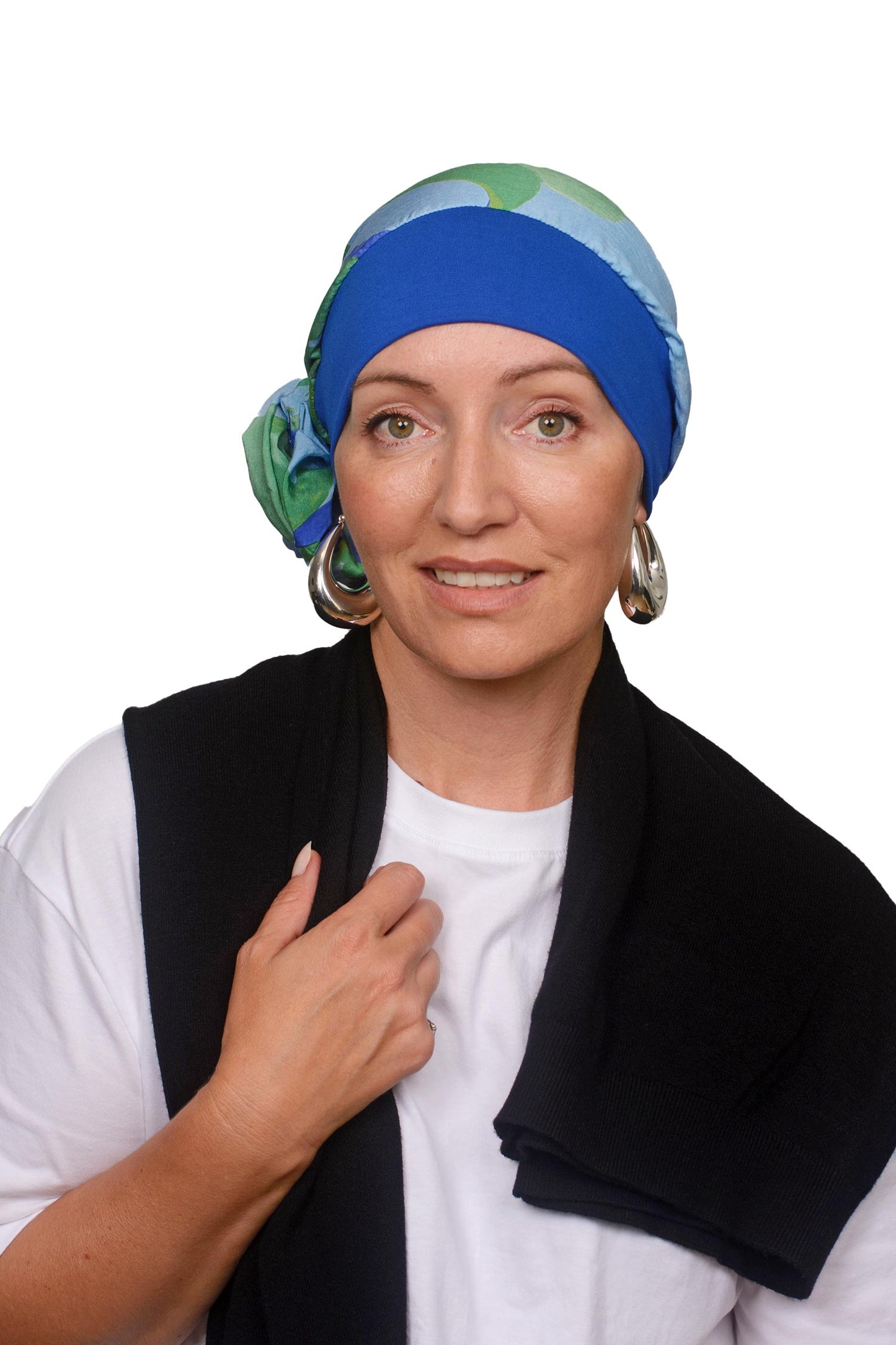 Women wearing a blue and watercolour scarf with band for cancer as a headcovering