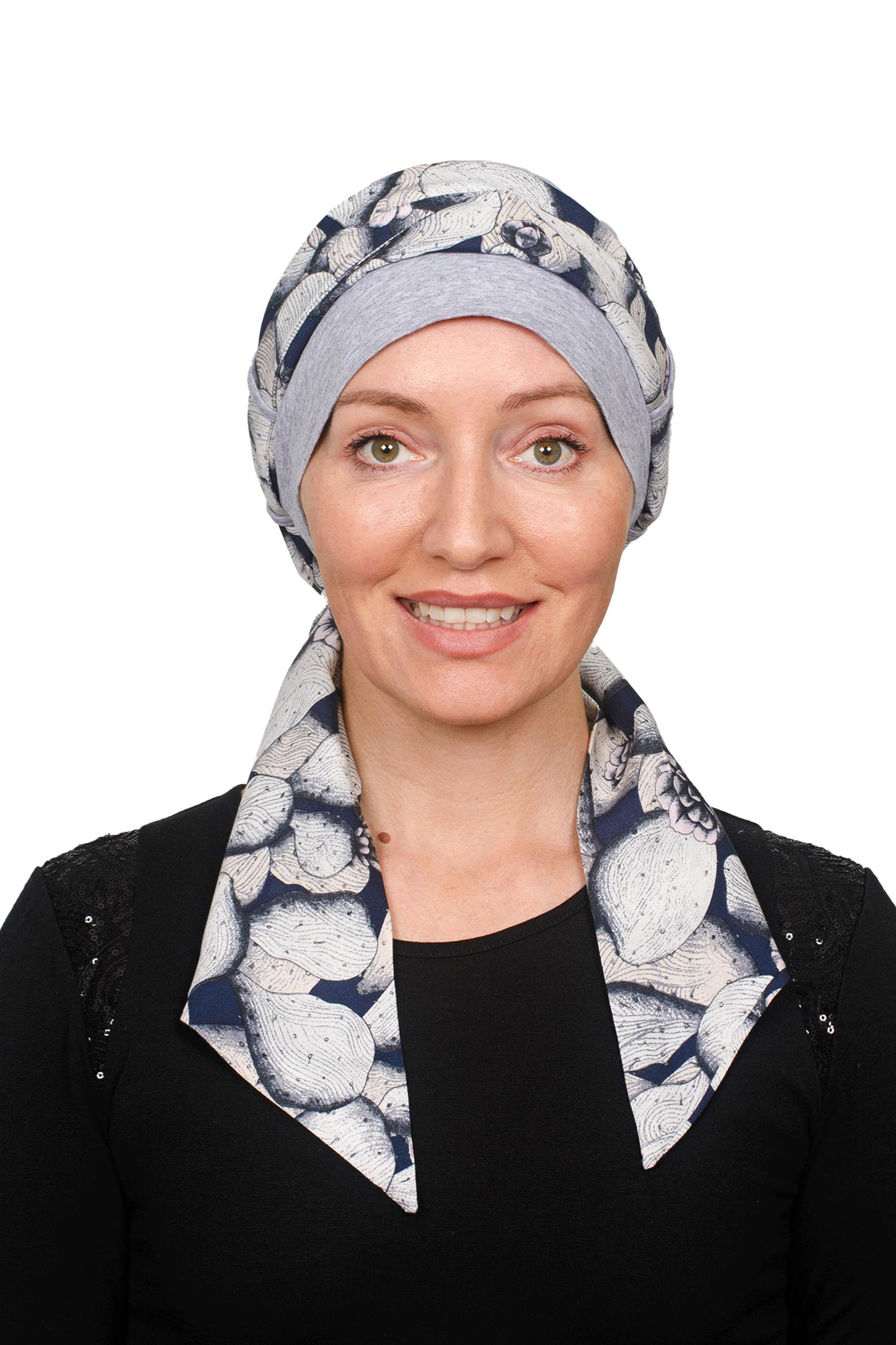 A women wearing a grey silver cancer cap with a scarf threaded through as a headwrap