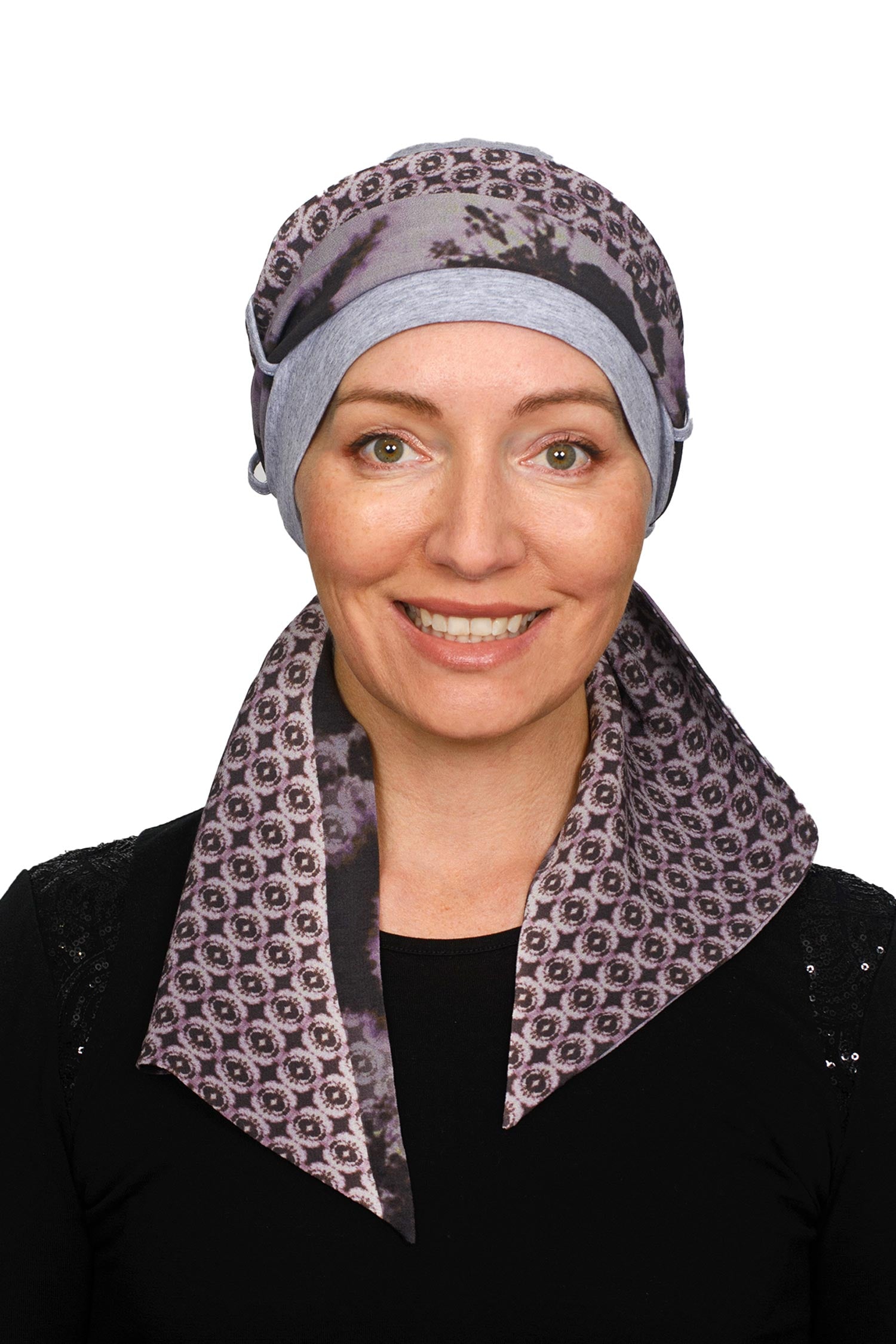 A women wearing a cancer cap with cancer headscarf in muted colours as a headcovering.