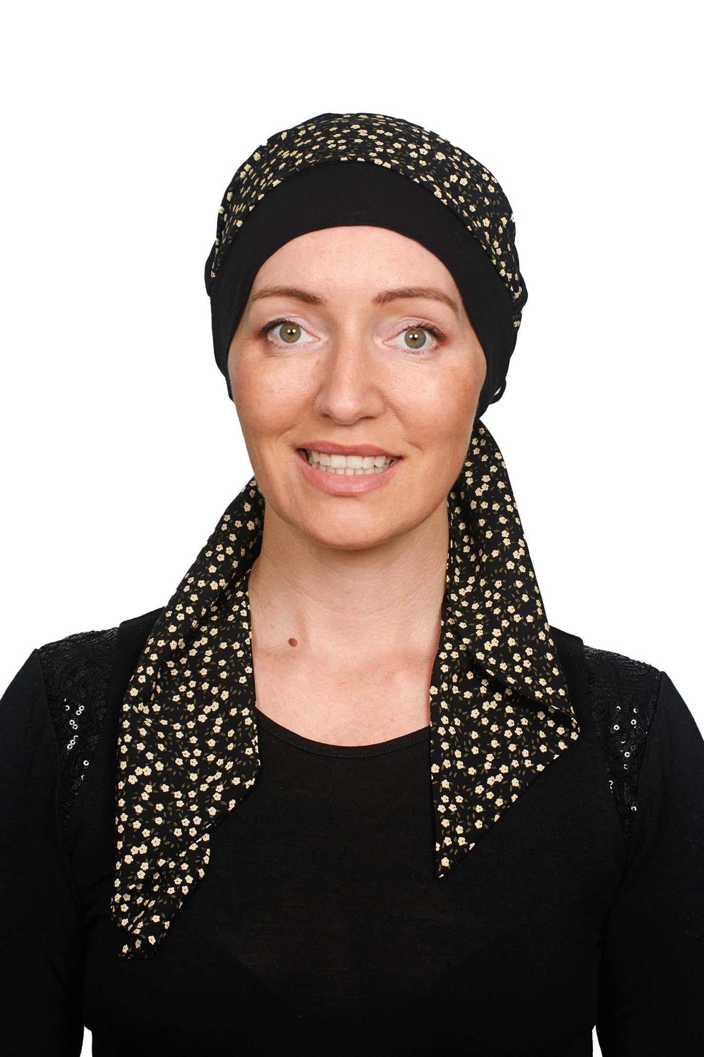A women wearing a black cancer hat with a ditsy floral scarf as a headcovering