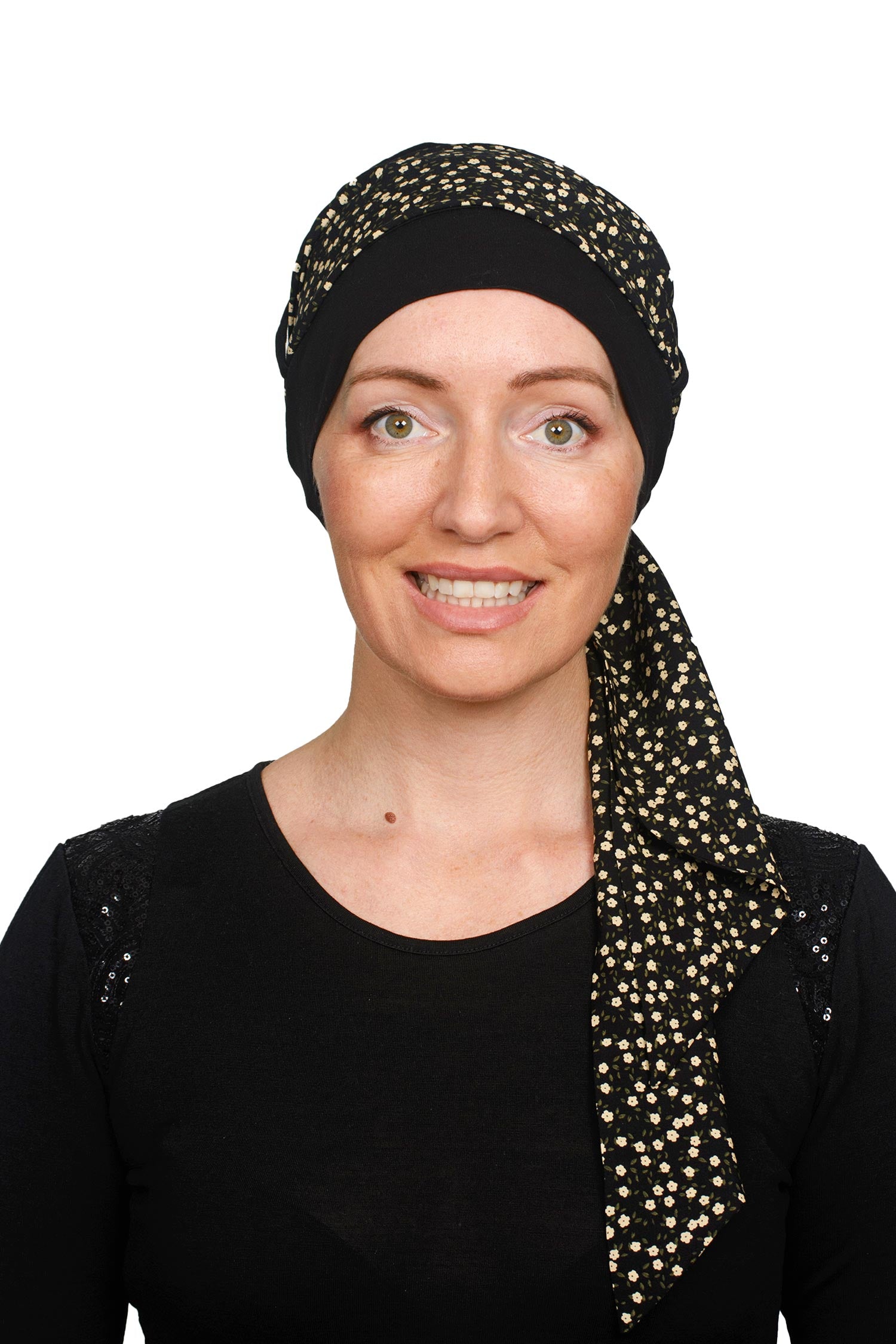 A women wearing a black cancer hat with a ditsy floral scarf as a headcovering
