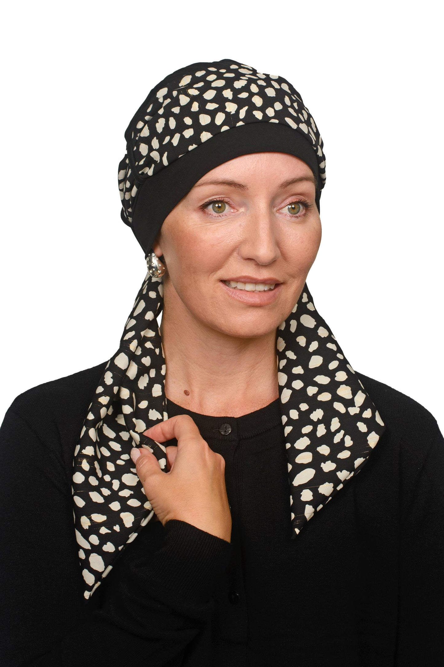 Women wearing a black cancer cap with an animal printed scarf with lurex through it as a head covering