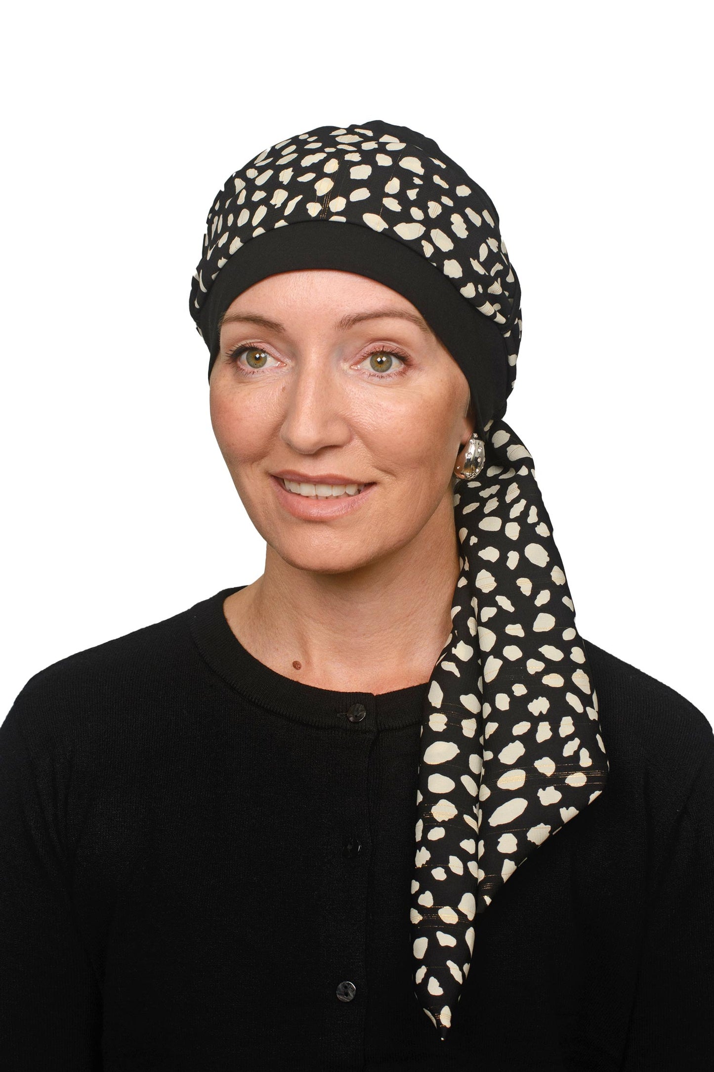 Women wearing a black cancer cap with an animal printed scarf with lurex through it as a head covering
