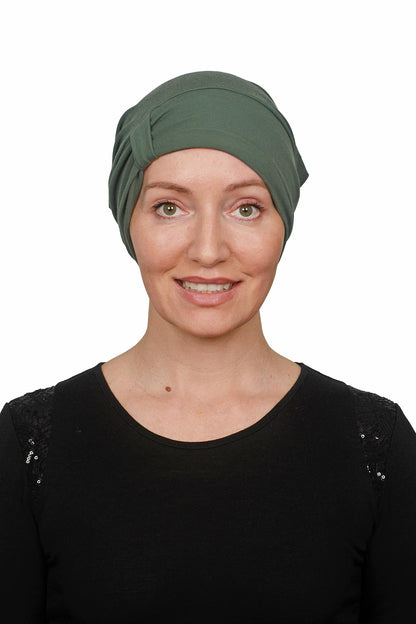 Woman wearing a cancer green headscarf on a white background