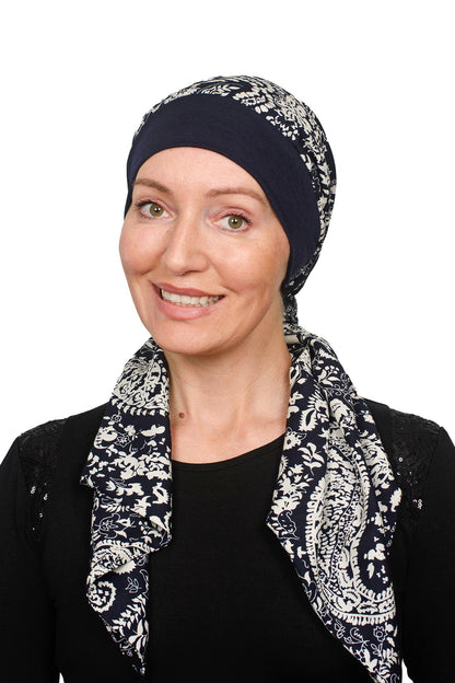 Women wearing a banded cancer hat with a scarf attached in a dark ink as a headcovering