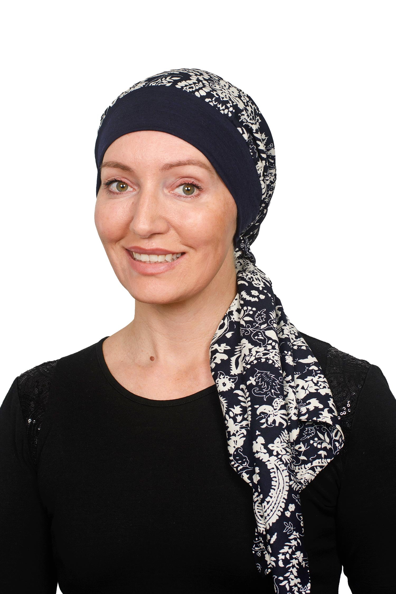 Women wearing a banded cancer hat with a scarf attached in a dark ink as a headcovering