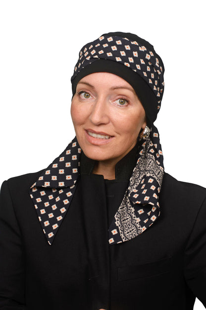 A woman wearing a black and beige patterned headscarf and matching neck scarf, paired with a black blazer, against a plain white background.