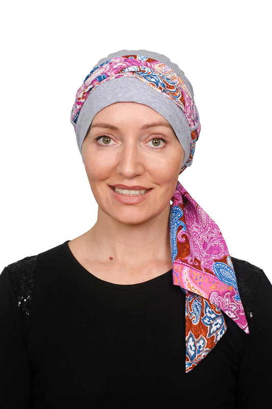 Women wearing a cancer cap with a soft colourful scarf through it as a head wrap
