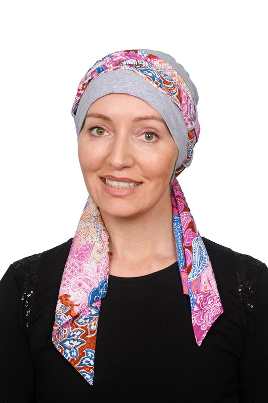 Women wearing a cancer cap with a soft colourful scarf through it as a head wrap