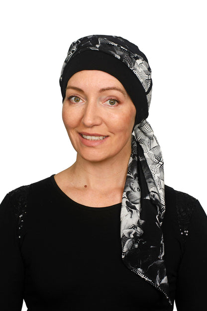 A women wearing a cancer cap with cancer headscarf in black and white colours as a headcovering.