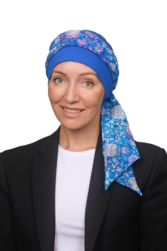 Women wearing a cancer cap with a head scarf in it in blues and paisley print as a head covering