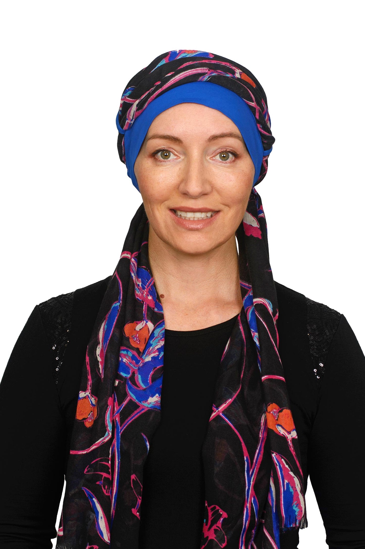 A women wearing a ocean blue cancer hat with a floral scarf as a headcovering