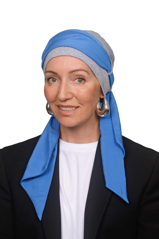 Women wearing a grey silver cap with a blue headscarf in it for cancer as a headcovering