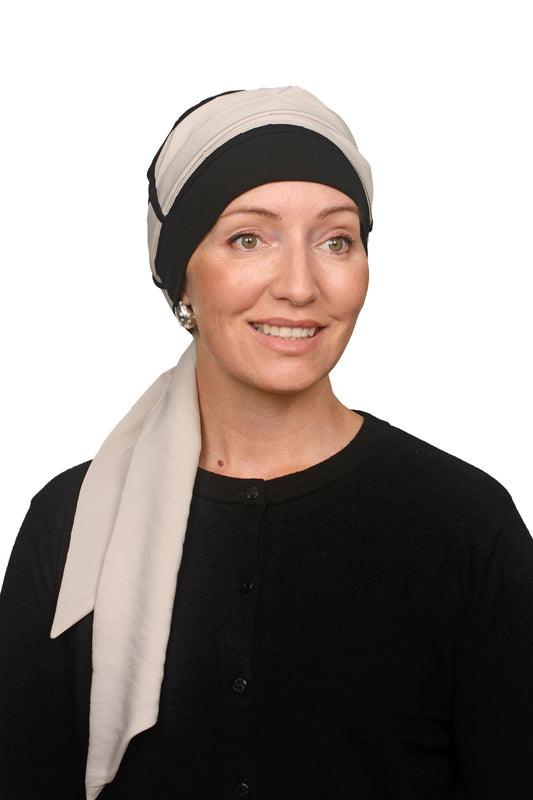 Women wearing a black cap for cancer with a scarf through it as a headcovering