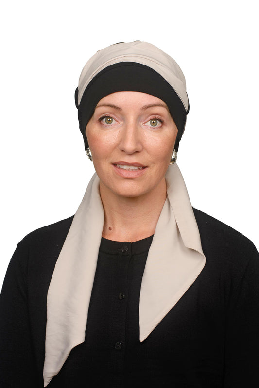 Women wearing a black cap for cancer with a scarf through it as a headcovering