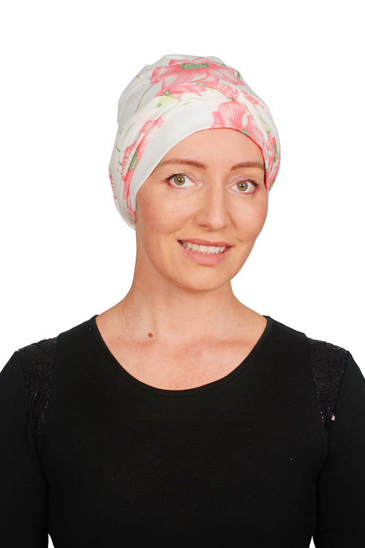 A women wearing a cancer headwrap in cream with pink flowers on it for cancer