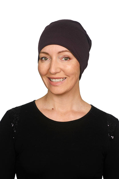 Women wearing a cancer hat in a dark purple as a head covering.