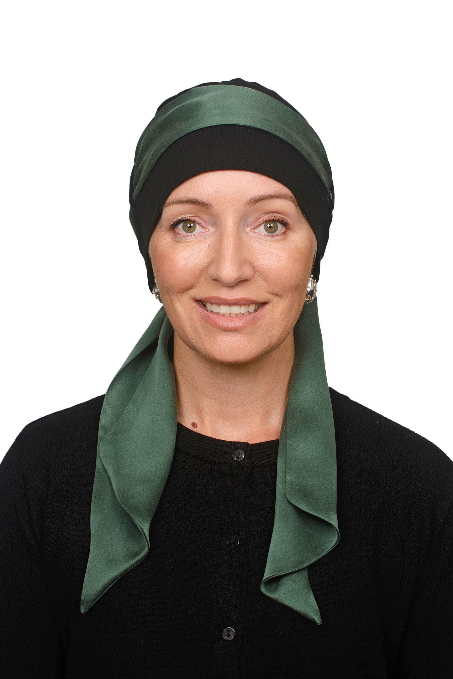 Women wearing a black cancer cap with a sandwashed silk scarf in green through it as a headcovering