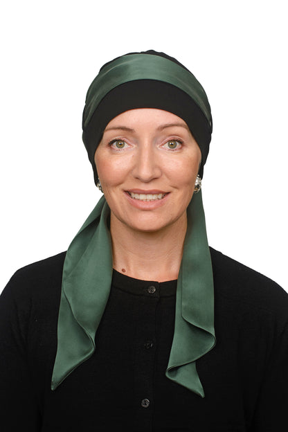 Women wearing a black cancer cap with a sandwashed silk scarf in green through it as a headcovering