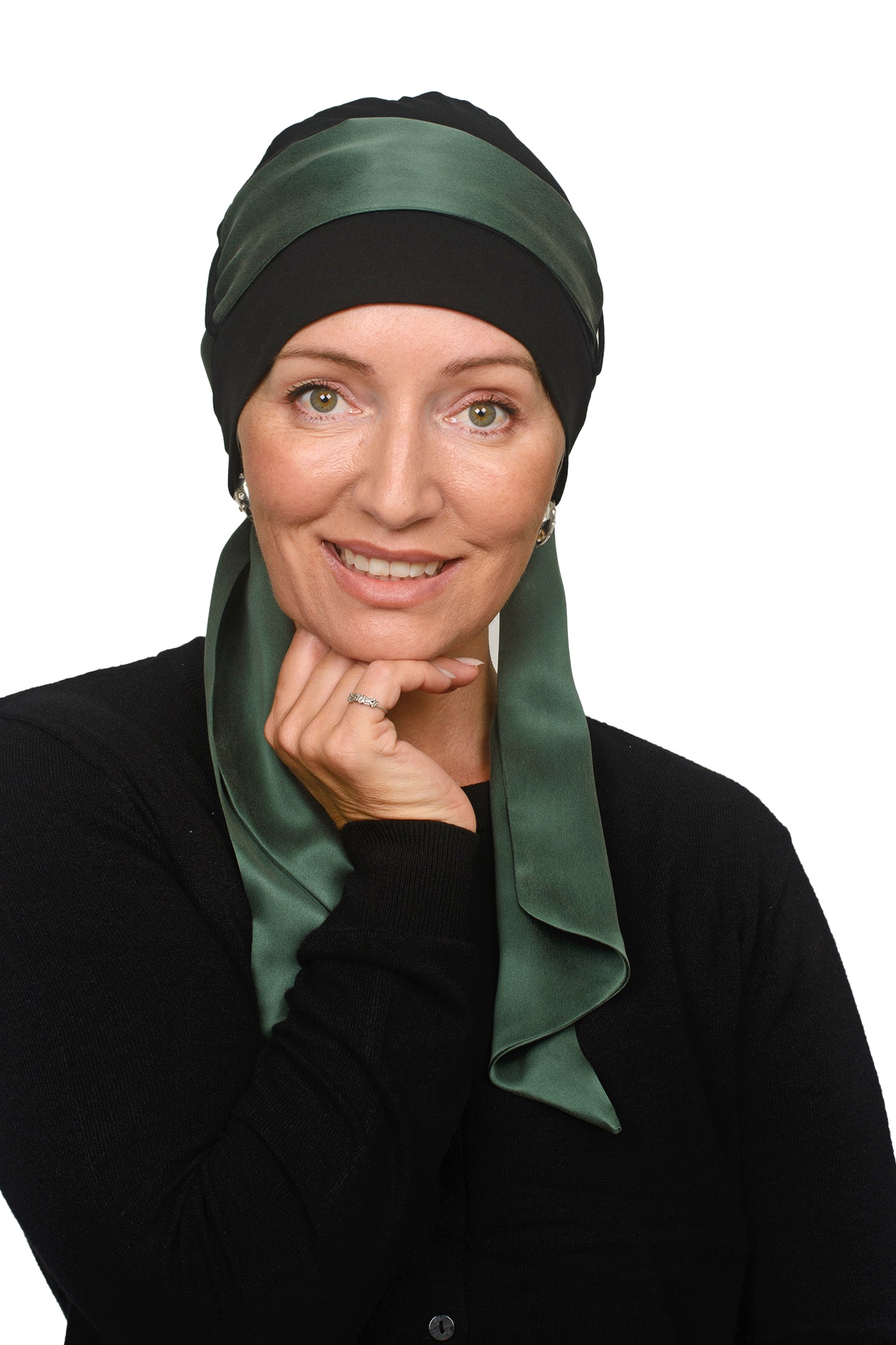 Women wearing a black cancer cap with a sandwashed silk scarf in green through it as a headcovering