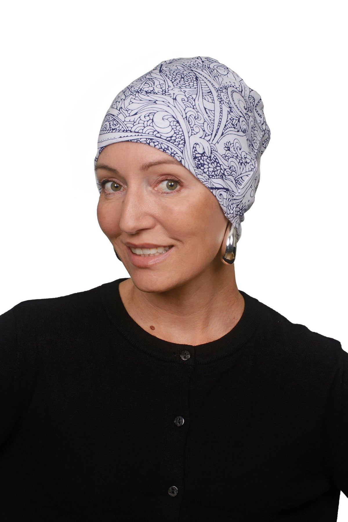 A woman wearing a light blue and navy blue paisley patterned fabric head covering, paired with a black top, photographed against a solid white background.