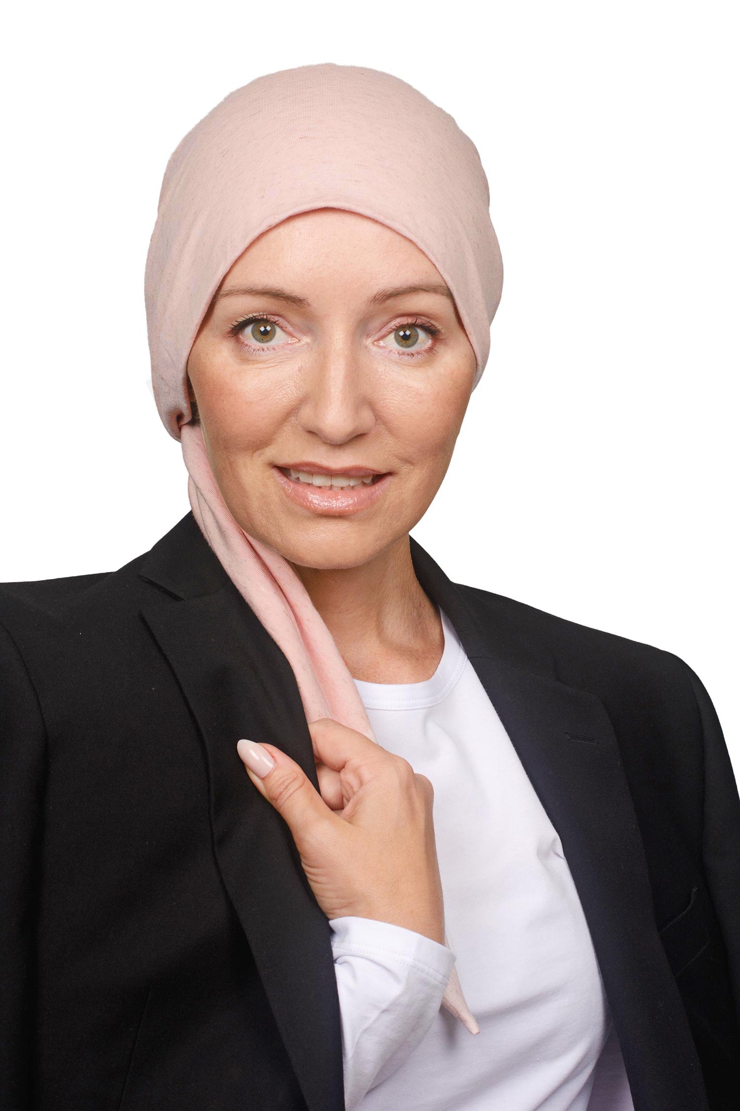 A woman wearing a light pink head wrap and a black blazer over a white shirt, posing against a solid white background.