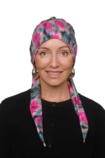 women wearing a cancer hat covering in pink and green wrapped around her head as a head covering
