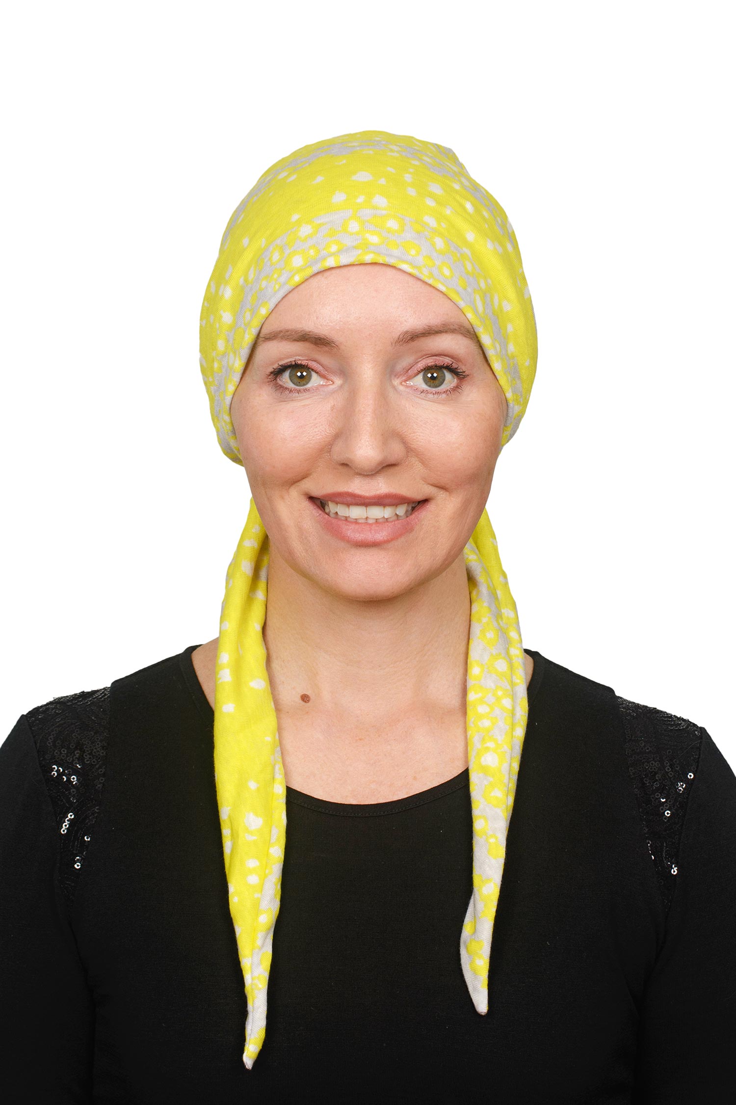 Women wearing a cancer scarf made out of linen in a yellow colour wrapped around her head as a headcovering