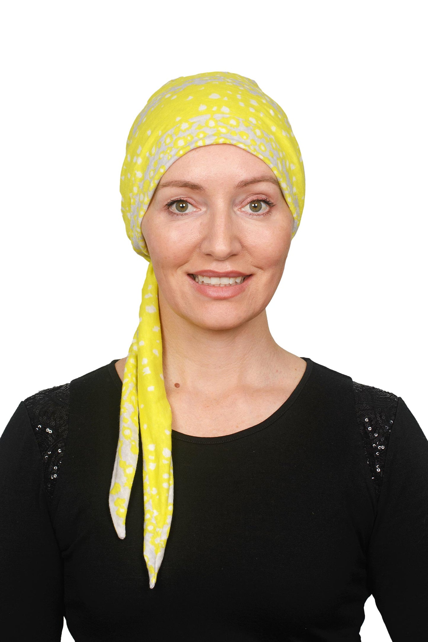 Women wearing a cancer scarf made out of linen in a yellow colour wrapped around her head as a headcovering