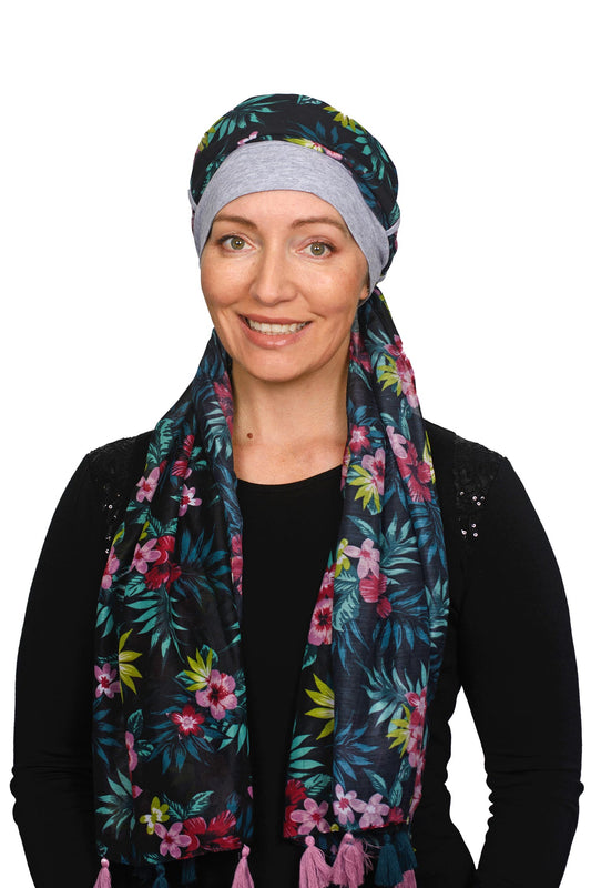 Women wearing a silver cap for cancer with a scarf that is long and colourful worn as a head wrap