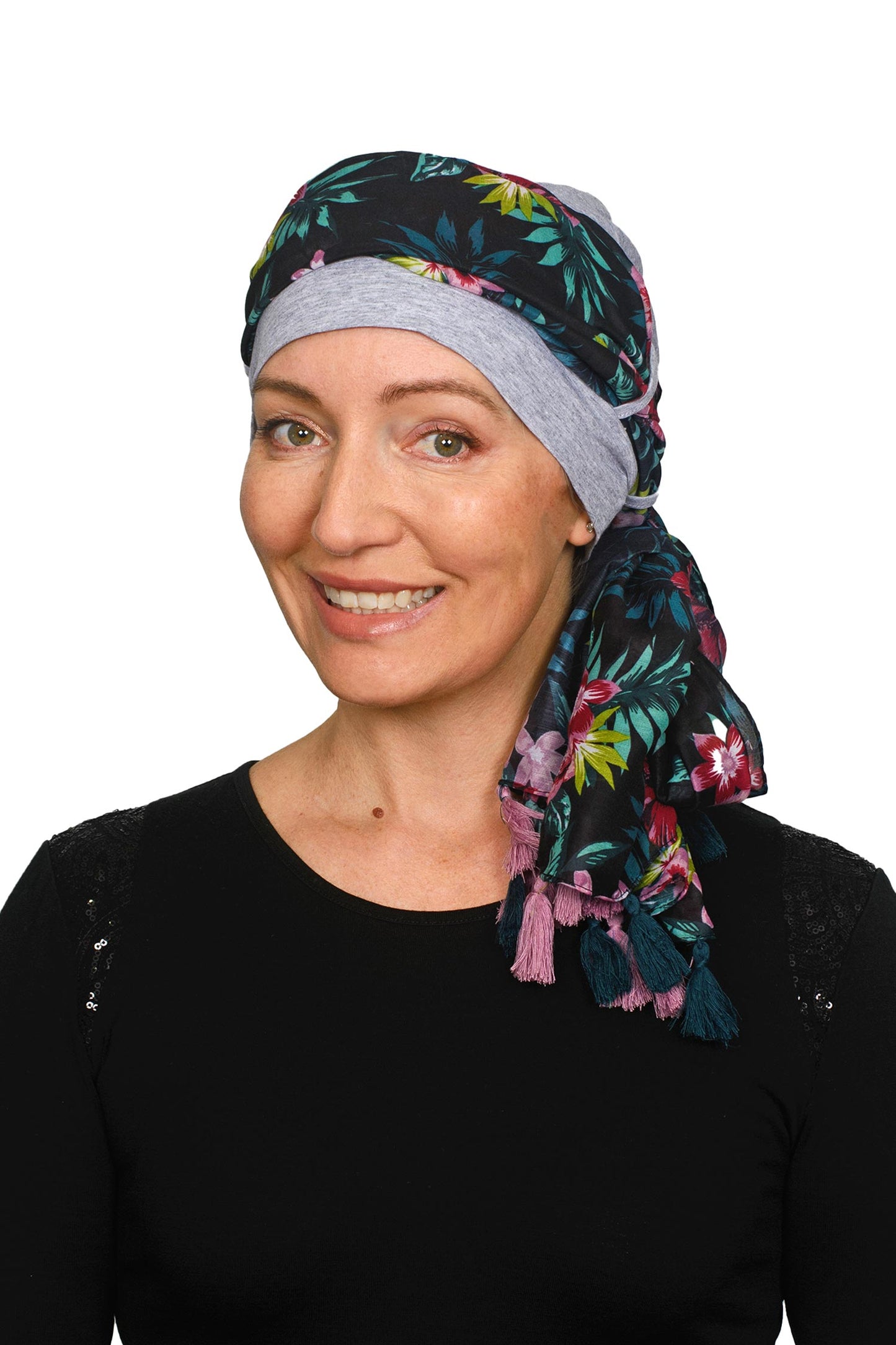 Women wearing a silver cap for cancer with a scarf that is long and colourful worn as a head wrap