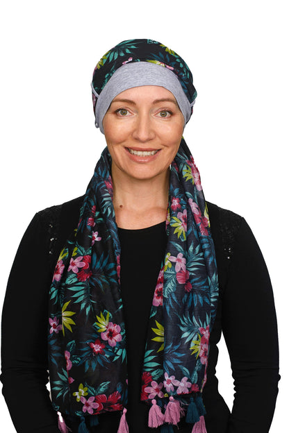 Women wearing a silver cap for cancer with a scarf that is long and colourful worn as a head wrap