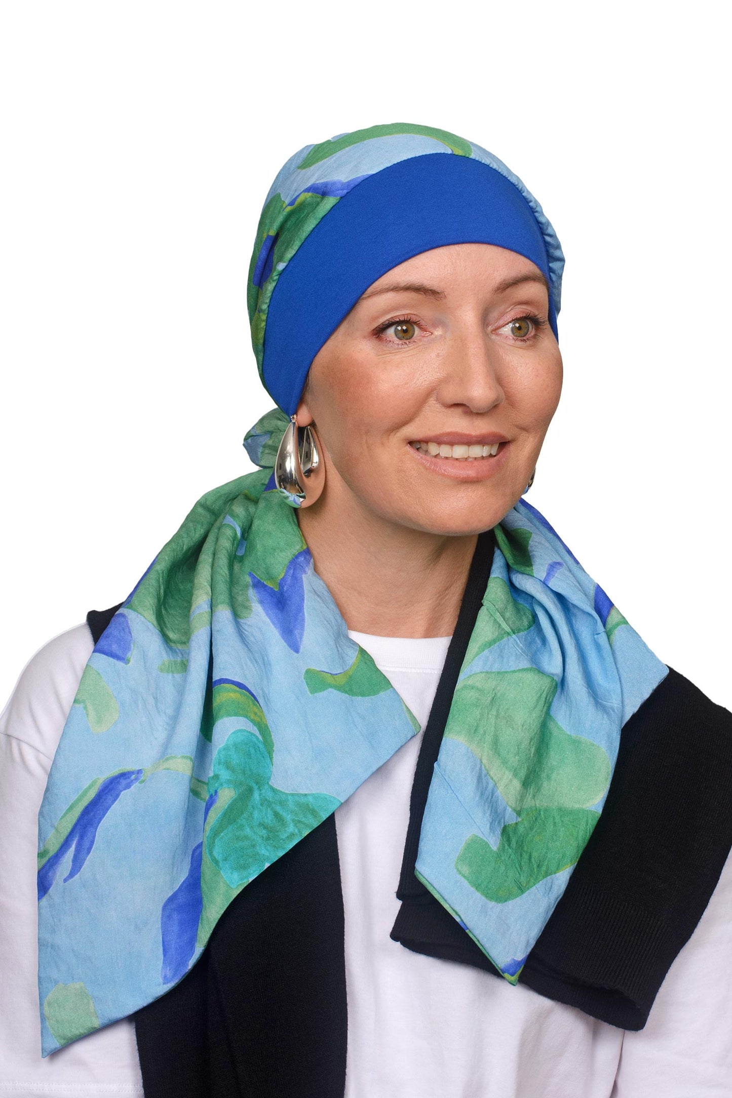 Women wearing a blue and watercolour scarf with band for cancer as a headcovering