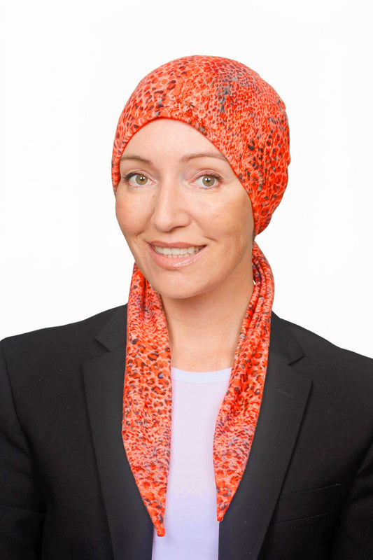 Women wearing an orange cotton wrap hat as a head covering for hair loss